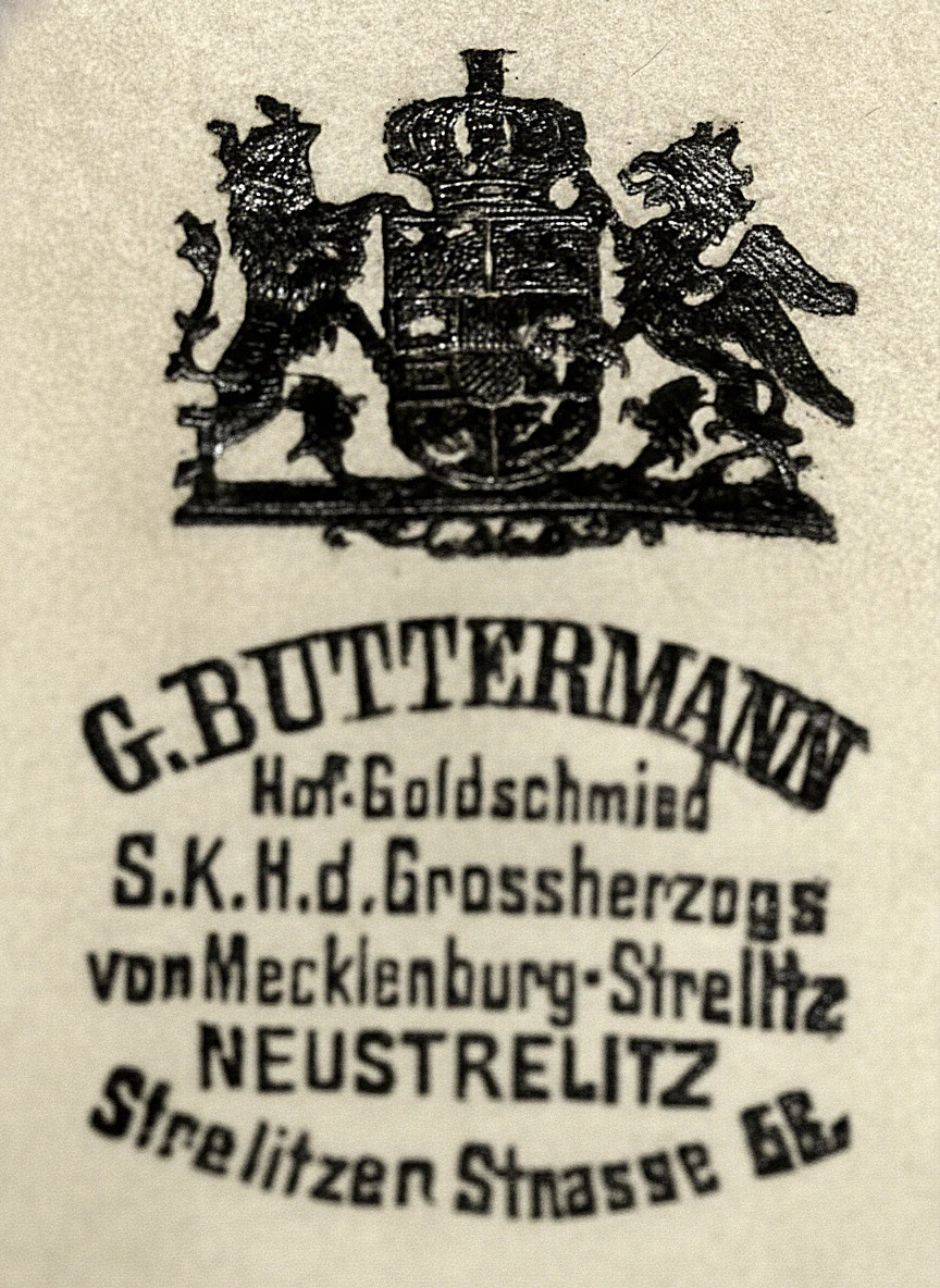Herstelleraufdruck auf dem Atlaskissen des Etuis der Firma G. Buttermann.